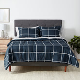 Amazon Basics comforter set on bed in navy and grey plaid, soft microfiber