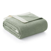 AmΓ©lie Home chenille waffle throw with soft touch draped over a sofa for cozy comfort.