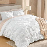 Andency white full-size comforter on bed showing pinch pleat elegance for refined decor.