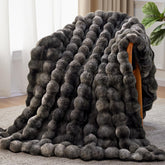 Anysay faux fur throw blanket draped over a sofa for cozy living room warmth.