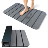 ArtyCozy large stone bath mat in grey, rolled for compact storage and easy handling.