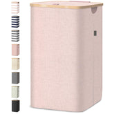 BALEINE laundry hamper with pink lid and bamboo rim keeps laundry tidy.