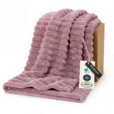 Bedsure GentleSoft pink fleece blanket draped on a couch for cozy living room warmth.