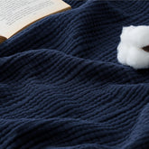 Bedsure navy muslin blanket on sofa for cozy couch decor and breathable comfort