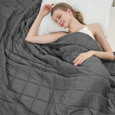 BETU weighted blanket in grey on bed delivers calming, cozy sleep support.