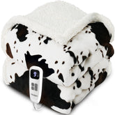 Blunique heated blanket in cow print white, folded for storage