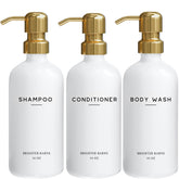 Brighter Barns gold shampoo dispenser set on a modern bathroom shelf for spa-like organization.