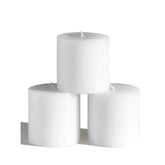 CANDWAX 3x3 pillar candles on a tablecape deliver warm, steady light.