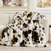 Cozy Bliss cow-print faux fur throw on sofa for chic comfort.