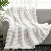 Cozy Bliss faux fur throw blanket on sofa with creamy texture.