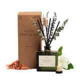 Craft and Kin Santal Woods diffuser bottle with dried flowers enhances room ambiance.
