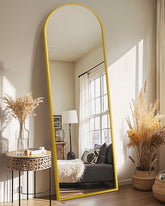 Delma full length mirror with gold arch frame reflecting daylight in a stylish bedroom