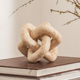 DN DECONATION 3-link knot decor beige travertine closeup, tactile surface and stone-like finish