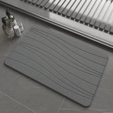 Drvykkn fast drying stone bath mat in dark gray wave shows rapid moisture evaporation
