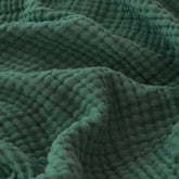 EMME forest green blanket on sofa, breathable comfort for lounging