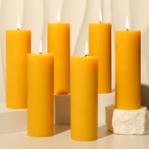 Ginitiri 6-pack natural beeswax pillar candles on a table provide long-lasting ambient light.