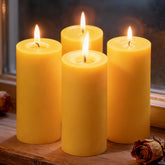 Ginitiri beeswax pillar 4-pack front view showing natural color and warm ambient glow.