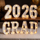 Glimmrly Grad LED letters illuminate a table centerpiece for a graduation setup.