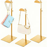Hacaroa gold 3-pack purse display stands on shelf.