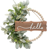 Idyllic green wreath for front door with wood beads and delicate lambs ears leaves, ideal for seasonal charm.