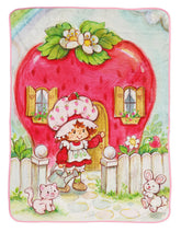 Jay Franco Strawberry Shortcake plush throw blanket on sofa for cozy evenings.