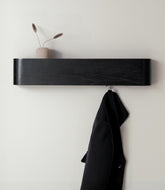 Kazai Toke wall-mounted coat rack with hidden hooks keeps entryway clutter-free.
