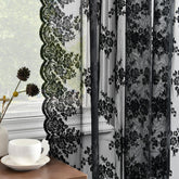 Kotile black lace curtains pair hanging on a rod, offering soft light and added privacy.