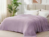 Kozyhvn lavender muslin blanket on bed highlighting breathable six layer design.