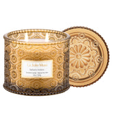 LA JOLIE MUSE Sahara Amber Candle in embossed daisy jar adds elegant decor and scent.