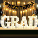 Lovelite GRAD sign four-letter set on a table centerpiece with warm glow