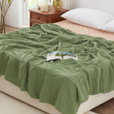 Love's cabin sage green muslin blanket on bed for breathable comfort