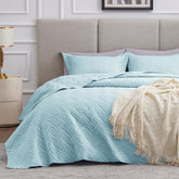 Love's cabin wave-pattern quilt in light blue adds soft texture to the bed.