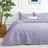 Love's cabin king quilt in lavender sits on a bed for year-round comfort.