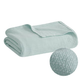 Madison Park Freshspun Basketweave Cotton Blanket blue draped over bed for year-round comfort.