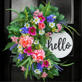 NaturaWre 24-inch Spring Wreath with wooden welcome sign enhances curb appeal.