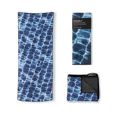 Nomadix Original Towel on sunny beach scene highlighting sand resistance and ample coverage.