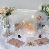 OurWarm acrylic wedding card box with string light, creating a romantic reception table decor.