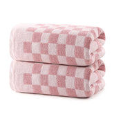 REDKISS pink checkered bath towel set in a bathroom, plush and highly absorbent.
