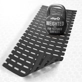 SlipX Solutions weighted bath mat on textured tub surface for secure placement.