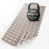 SlipX Solutions weighted non-slip bath mat on textured tub surface for secure footing.