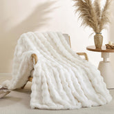 Smoofy cream white faux fur throw on couch, delivering luxurious warmth and a plush look.