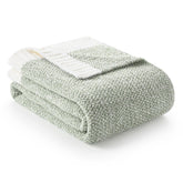 Snuggle Sac sage green throw blanket 50x70 on bed for cozy lounging