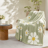 Snuggle Sac Spring Flower Throw Blanket on sofa, showcasing cozy microfiber warmth.