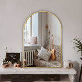 TRAHOME arched mirror with gold frame enhances bathroom light and depth.