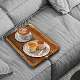 Vibaruta sofa tray square on couch with warm acacia wood, ideal for drinks and remotes.
