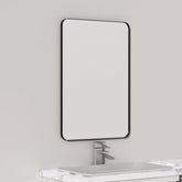 VocalStar mirror with 16x24 black metal frame mounted over a bathroom vanity for balanced, bright reflections.