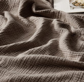 WDCOZY muslin throw blanket folded on sofa for warmth and style