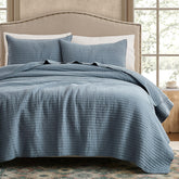 WDCOZY quilt set on bed with blue striped pick stitch for cozy styling.