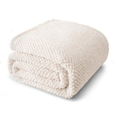 Whale Flotilla king-size fuzzy fleece blanket ivory folded on ottoman for display