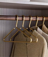 WONQEXZ premium matte gold aluminum hanger closeup showing a smooth surface for delicate fabrics.